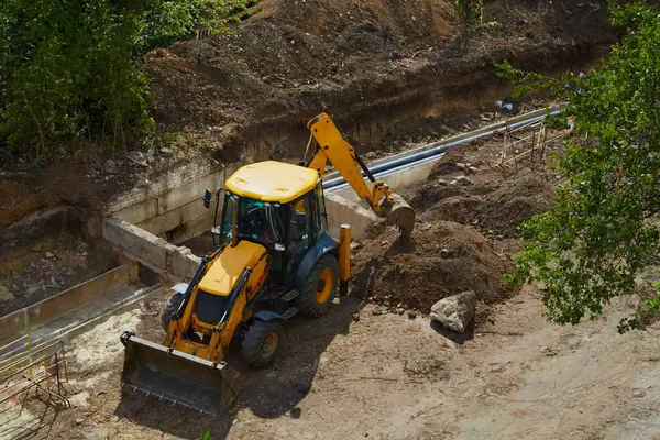 Kazıcı ve su boru hattı inşaatı, boru döşeme işleri, inşaat alanında çukur kazma.
