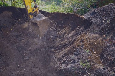 İnşaat sahasında çalışan kazıcı kovası yakın plan çekimde. 