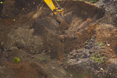 Kazı kovası bir inşaat alanından toprağı topluyor.
