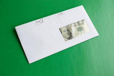 Yeşil arka plan, finansal ödeme, nakit rüşvet, mali posta çeki zarfında 100 dolar.
