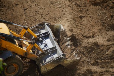 Buldozer kovası zemini dümdüz ediyor, buldozer kovası zemini düzlüyor, yakın plan.