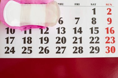 Adet takvimi ve defter yakın çekim, regl günleri için kadın takvimi, sağlık sigortası jinekolojik konsepti.