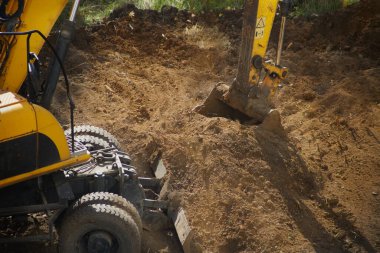 Kazı makinesinin kovası toprağa gömülür.