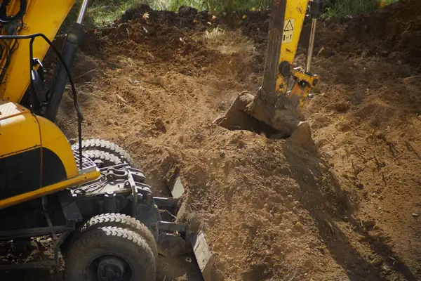Kazı makinesinin kovası toprağa gömülür.