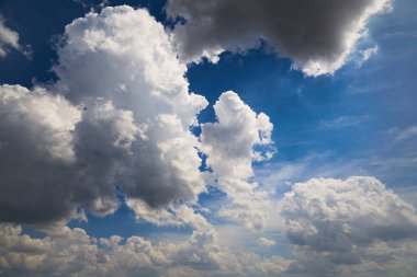 Mavi gökyüzünde büyük kümülüs bulutları, hava değişimi, değişken bulutlar, güneşi kaplayan bulutlar.