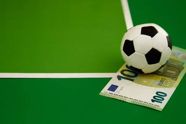 Futbol topu ve yeşil arka planda 100 Euro köşe vuruşu, spor tahmini, bahisçi bahisçi, spor bahisleri