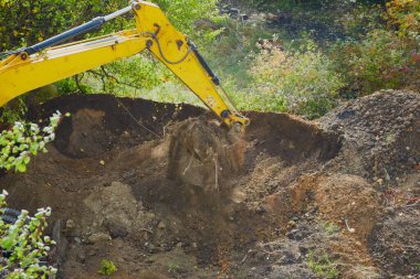 Kazı kovası zemini kazıyor, kazıcı operasyonu, yakın plan.