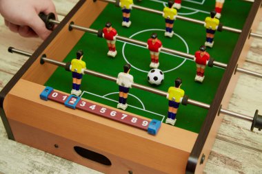 Langırt oyununda kontrol kolunu tutan el, futbol masası oyunu.