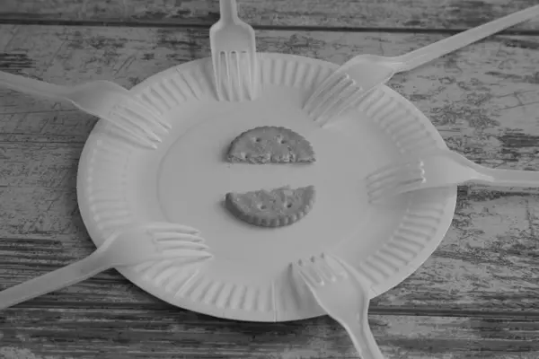 Ahşap arka planda altı çatallı bir kurabiye yakın plan, siyah beyaz fotoğraf, yiyecek eksikliği, artan gıda fiyatları, yetersiz beslenme, yiyecek kıtlığı.