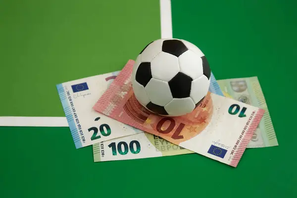 Futbol topu ve avroluk banknotlar yeşil arka plan, spor bahisleri, futbol topu ve para ile geçmiş