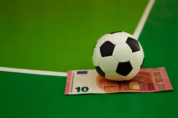 Futbol topu ve 10 avroluk banknot yeşil arka planda bir gkak, yakın plan, spor tahmini, bahisçi bahis, spor bahisleri, para oyunu üzerine bahis