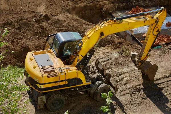 Bir inşaat sahasında duran kazıcı kova yere indirilmiş, iş molası, temel inşaatında kazıcı...