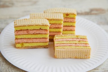 Dilimlenmiş sünger keki tek kullanımlık beyaz bir tabakta yakın plan bir masada.