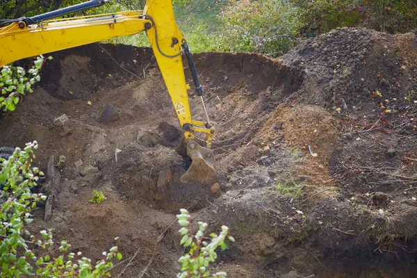 Kazıcı, inşaat alanındaki yakın çekimde yerde çalışıyor. 