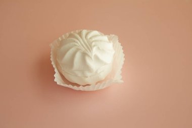 Beyaz ambalajlı pembe zemin üzerinde beyaz marşmelov kağıt tartta beyaz marşmelov pembe zemin üzerinde narin tatlı