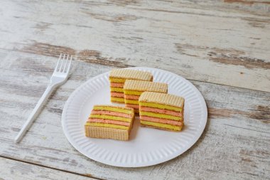 Gözleme ve reçelli sarı pembe sünger kek, beyaz tabak, ev yapımı kek, meyveli kek, yakın plan.