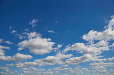 Mavi gökyüzünde beyaz bulutlar ufukta