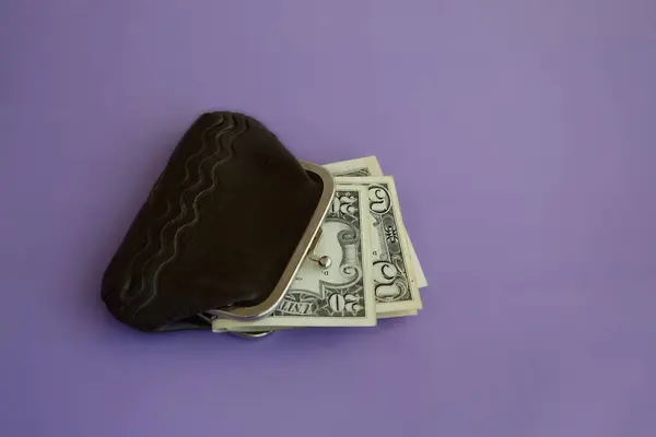 Leylak arka planında dolarları olan eski açılmış cüzdan yakın plan, küçük emekli maaşı, sosyal güvenlik yardımı, mali tasarruf