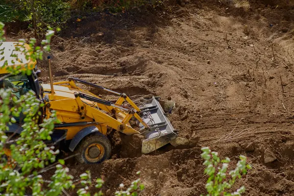 İnşaat alanındaki toprak çalışmaları: yeşilliğe karşı zemini düzleştiren buldozer.