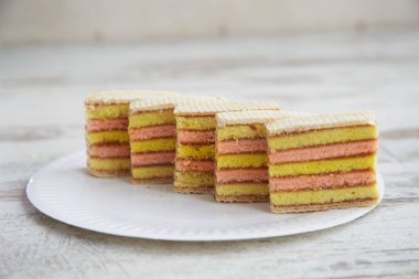 Tahta bir masada çatalla beyaz bir tabakta katmanlı sünger keki, yakın plan meyve süngeri, tabakta sünger keki.