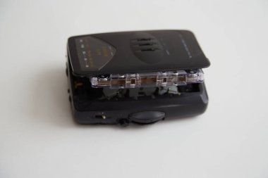 Beyaz arka planda ses kaseti olan eski siyah ses oynatıcı, eski teknolojiler, eski müzik, eski teknolojiler