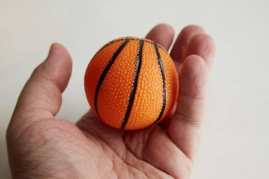 Hafif bir arka plan, basketbol maçı, spor hatıra eşyası ürünü, yakın planda tutulan küçük basketbol topu.