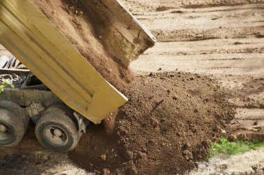 Toprak bir kamyon yatağından dökülüyor. Yakın planda, toprak dökülüyor..