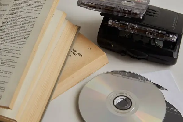 Küçük disk, ses kaydı ve beyaz bir masaya kitap, eski ve yeni İngilizce öğrenme yöntemleri.