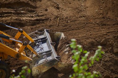 Buldozer zemini yakın mesafeden dümdüz ediyor, buldozer kovası zeminle çalışıyor, buldozer toprak işliyor, buldozer kovası zemini temizliyor. 