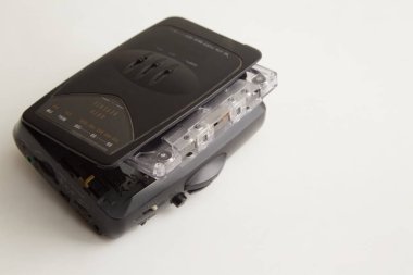 Beyaz arka planda açık destesi ve ses kaseti olan eski siyah ses oynatıcısı, eski teknoloji, eski müzik, eski teknoloji, unutulmuş melodiler