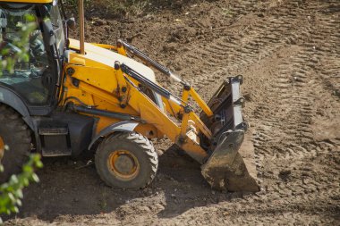 Kovalı sarı renkli buldozer inşaat sahasında, buldozer sahasında çalışır.