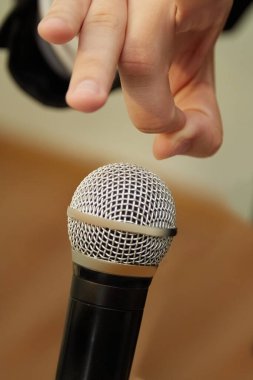 Mikrofona, provokasyona, canlı yayında yaramazlığa, mikrofon kontrolüne hazır parmaklar.