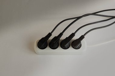 Siyah elektrik prizleri beyaz paneldeki tüm prizlere yerleştiriliyor, güç sistemi aşırı yükleniyor, elektrik kesintisi var, şarj için boş yer yok.