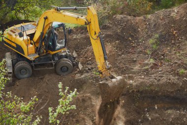 Toprak çalışmalarının tamamlanması: kazıcı kazıyı tamamlar., zemin çalışması; inşaat alanı ve mekanik çalışma; siteprezasyon ve toprak taşımacılığı