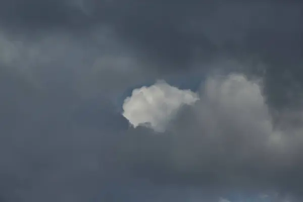 Gri bulutların arasında beyaz bulutlu bir boşluk, gri bulutlarda bir boşluk.