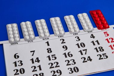 Haftanın her günü mavi bir takvime yerleştirilmiş hap paketleri, tedavi zamanı, hap alma zamanı, sürekli hap alımı.