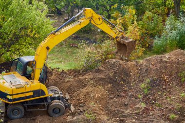 İnşaat alanındaki kazıcının çalışma süreci. sitework ve temel çalışma, altçalışma; inşa alanı ve mekanik çalışma; siteprezasyon ve yer değiştirme