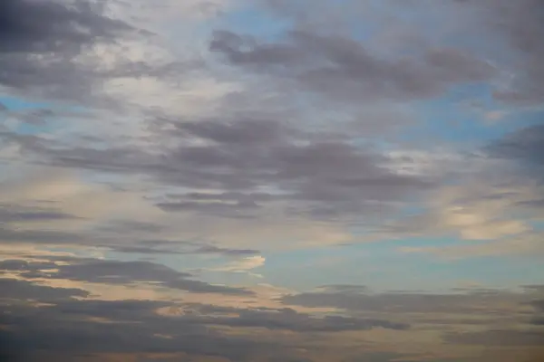 Gökyüzündeki bulutların üzerindeki batan güneş ışığının hassas renkleri, gökyüzü arkaplanı.