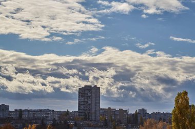 Şehrin üzerinde güçlü dikey gelişime sahip bulut kümülüs bulutları çağdaş bir şehrin binalarının üzerinde sonbaharın gelişini temsil ediyor..