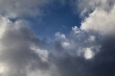 Gökyüzünde beyaz bulutlar ve aralarında mavi gökyüzünü, gökyüzünde yüksek bulutları yakından, bulutların arasından gökyüzünü görebilirsiniz.