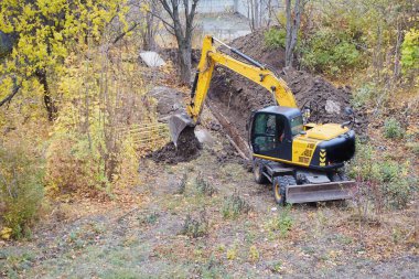 Kanalizasyon boruları olan bir siper kazıcı, kamu hizmetlerinde bakım işleri, toprak işleri yapan kazıcı..