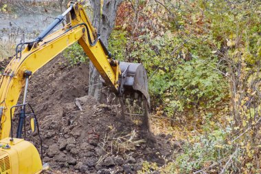 Toprağı hareket ettiren güçlü bir kazıcı kovasına yakın çekim.