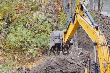 Toprak temizleyen bir kazıcı kovasına yakın çekim.
