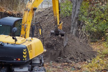 Kazı çalışmaları sırasında bir kazıcı toprağı topluyor..