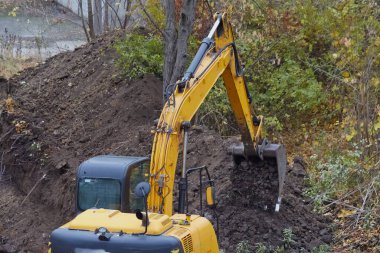 Kazıcı, inşaatın temelini atmak için hendek kazıyor..