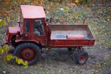 Arkasında kırmızı bir gaz silindiri olan eski kırmızı traktör, yanıcı madde taşıma ihlali, tehlikeli gaz silindirleri taşımacılığı 