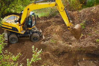 Kazı makinesi inşaat sahasındaki çukur, zemin çalışması, inşaat alanı ve mekanik çalışma; siteprezasyon ve toprak taşıma alanlarını kapsıyor