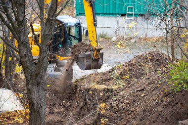 Earthworks with an excavator in the green zone of a construction area.