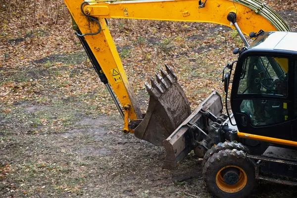 Excavator parts: bucket, boom and wheels, ready to work.