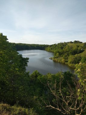 Ormandaki göl bulutlu mavi gökyüzüne karşı. Doğanın güzelliğindeki tasarımların için.